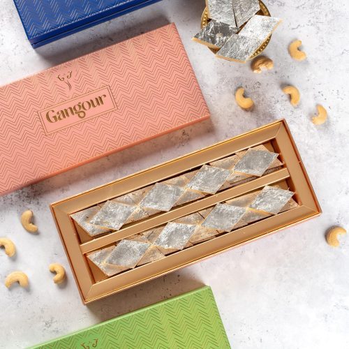 Kaju Katli sweets in a decorative gift box with silver leaf topping