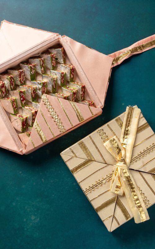 Handmade Gota gift boxes in vibrant colors with golden ribbon detailing.